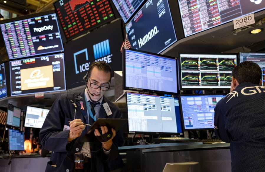 FILE - In this March 16, 2020 file photo, trader Gregory Rowe works on the floor of the New York Stock Exchange at the end of the trading day. Stocks are drifting between small gains and losses in early trading on Wall Street, Tuesday, Oct. 6, 2020, a day after a broad rally.