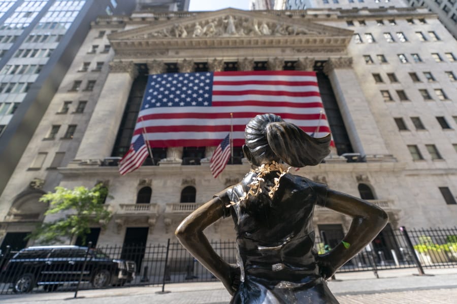 FILE  - In this Monday, Sept. 21, 2020 file photo, the &quot;Fearless Girl&quot; bronze sculpture looks towards the New York Stock Exchange.  Stocks are falling early Friday, Oct. 2 as Wall Street&#039;s first reaction to President Donald Trump&#039;s testing positive for the coronavirus was to retrench. The S&amp;P 500 was 0.9% lower after the first few minutes of trading, dropping with stocks around the world, Treasury yields and oil as investors pulled out of riskier investments and into safer ones.