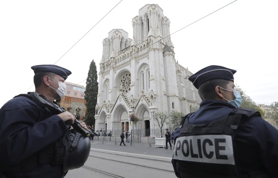 Police officers stand guard near Notre Dame church in Nice, southern France, Thursday, Oct. 29, 2020. An attacker armed with a knife killed at least three people at a church in the Mediterranean city of Nice, prompting the prime minister to announce that France was raising its security alert status to the highest level. It was the third attack in two months in France amid a growing furor in the Muslim world over caricatures of the Prophet Muhammad that were re-published by the satirical newspaper Charlie Hebdo.