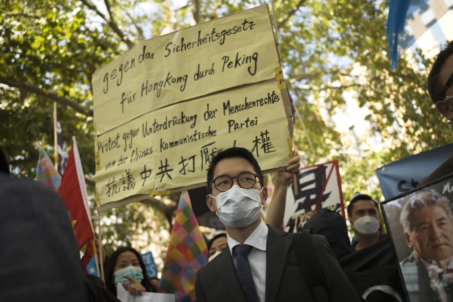 File---File picture taken Sept.1, 2020 shows Hong Kong activist Nathan Law, center, taking part in a protest during the visit of Chinese Foreign Minister Wang Yi in Berlin, Germany,   (AP Photo/Markus Schreiber,file)