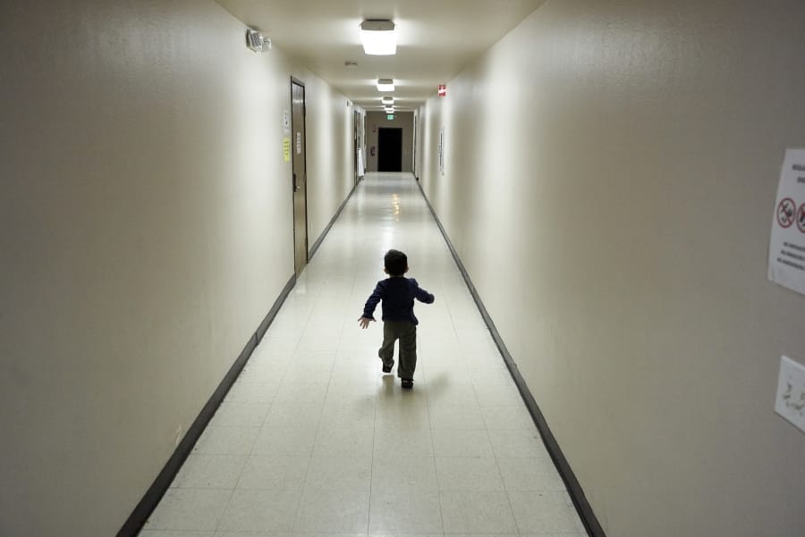 FILE - In this Dec. 11, 2018, file photo, an asylum-seeking boy from Central America runs down a hallway after arriving from an immigration detention center to a shelter in San Diego. A federal judge on Thursday, Oct. 22, 2020, urged the Trump administration to do more to help court-appointed researchers find hundreds of parents who were separated from their children after they crossed the U.S.-Mexico border beginning in 2017.
