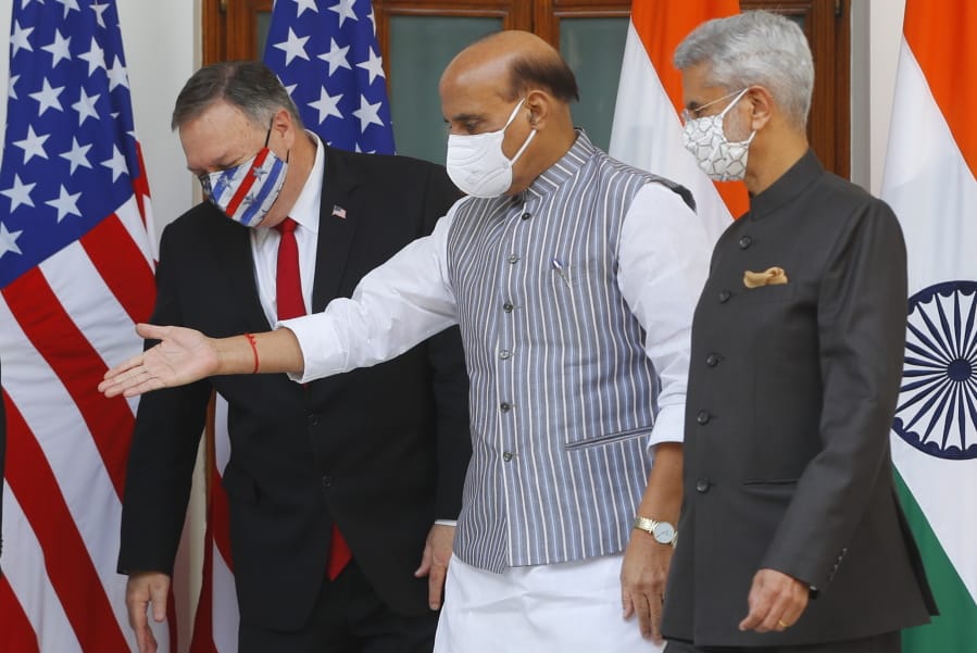 Indian Defence Minister Rajnath Singh, center, gestures towards U.S. Secretary of State Mike Pompeo, left, with Indian Foreign Minister Subrahmanyam Jaishankar, right, standing beside him, ahead of their meeting at Hyderabad House in New Delhi, India, Tuesday, Oct. 27, 2020. In talks on Tuesday with their Indian counterparts, Pompeo and Esper are to sign an agreement expanding military satellite information sharing and highlight strategic cooperation between Washington and New Delhi with an eye toward countering China.