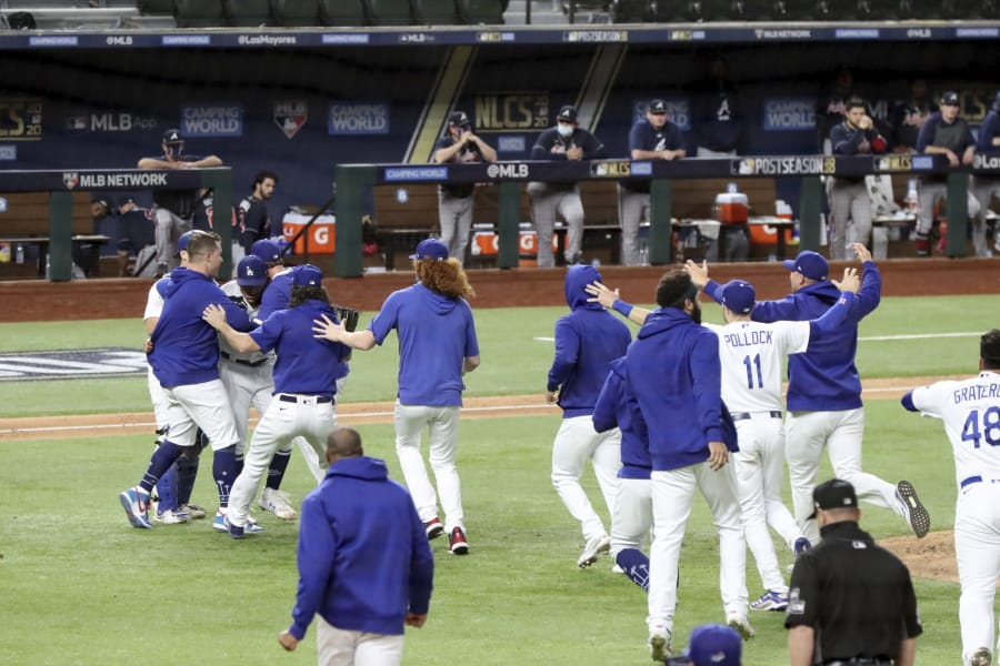 Los Angeles Dodgers players mob pitcher Julio Urias after they defeated the Atlanta Braves 4-3 in Game 7 of the National League Championship Series, Sunday in Arlington, Texas.