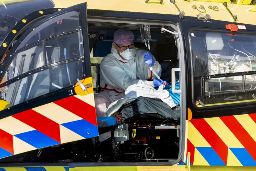 A COVID-19 patient is being tended to prior to being airlifted with the helicopter from FlevoZiekenhuis, or FlevoHospital, in Almere, Netherlands, Friday, Oct. 23, 2020.