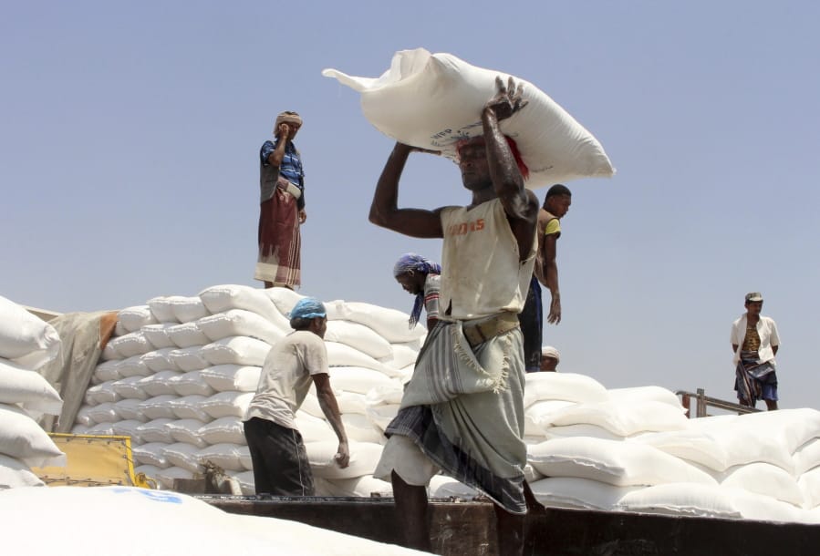 FILE - In this Sept. 21, 2018 file photo, men deliver U.N. World Food Program (WFP) aid in Aslam, Hajjah, Yemen. The World Food Program on Friday, Oct. 9, 2020 won the 2020 Nobel Peace Prize for its efforts to combat hunger and food insecurity around the globe.