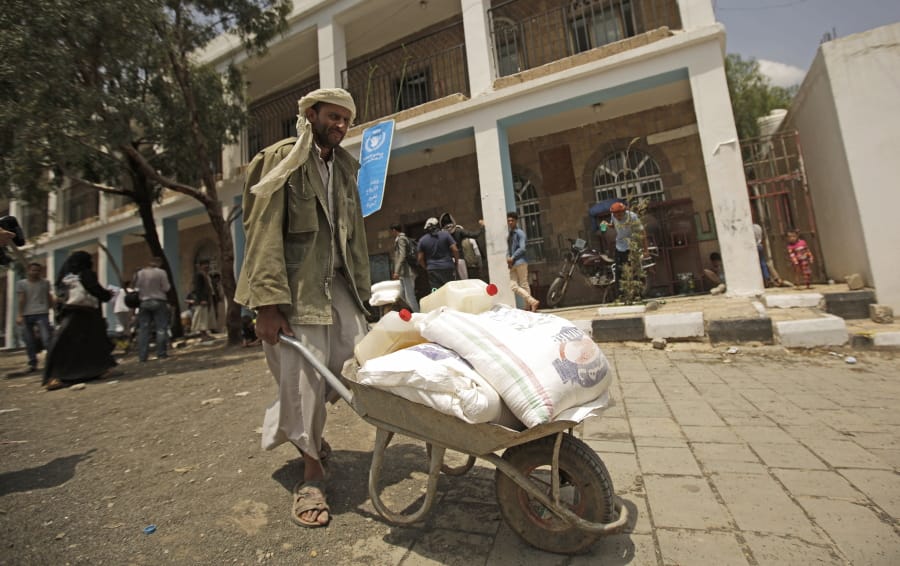FILE - In this Aug. 25, 2019 file photo, a displaced Yemeni receives food aid provided by the World Food Program, at a school in Sanaa, Yemen.  The World Food Program won the Nobel Peace Prize on Friday, Oct. 9, 2020 for its efforts to combat hunger amid the coronavirus pandemic, recognition that shines light on vulnerable communities across the Middle East and Africa that the U.N.
