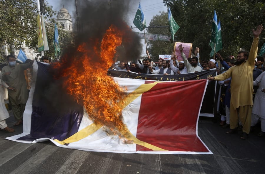 Supporters of religious group burn a representation of a French flag during a rally against French President Emmanuel Macron and republishing of caricatures of the Prophet Muhammad they deem blasphemous, in Lahore, Pakistan, Friday, Oct. 30, 2020. Muslims have been calling for both protests and a boycott of French goods in response to France&#039;s stance on caricatures of Islam&#039;s most revered prophet. (AP Photo/K.M.