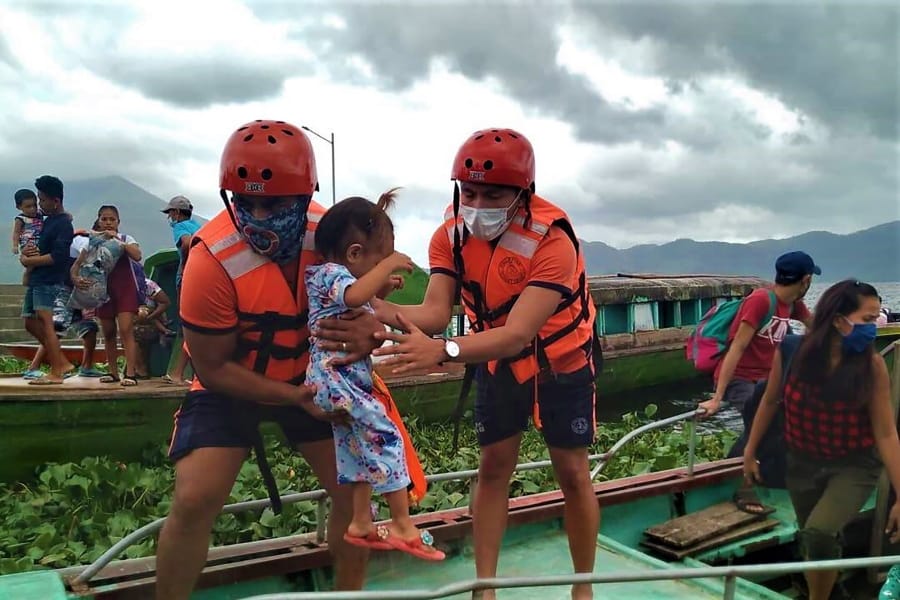 In this photo provided by the Philippine Coast Guard, members of the Philippine Coast Guard carry a child as they are evacuated to safer ground in Camarines Sur province, eastern Philippines on Saturday Oct. 31, 2020 as they prepare for typhoon Goni. Families living near coastal towns have started moving to evacuation centers as the strong typhoon approaches the country.