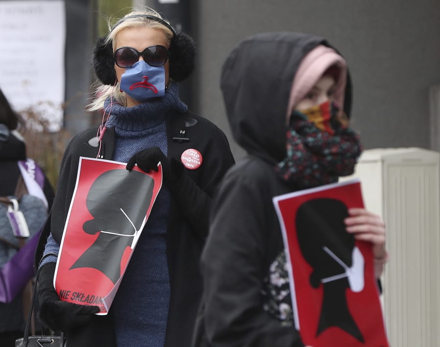 Women&#039;s rights activists, wearing masks against the spread of the coronavirus, protest against a draft law tightening Poland&#039;s strict anti-abortion law near the parliament that was debating the draft law, in Warsaw, Poland, on Wednesday, April 15, 2020.