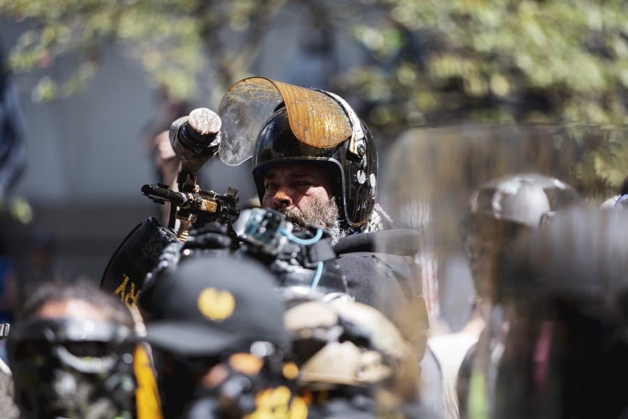 Alan Swinney points a paintball gun at a group of counterprotesters, Saturday, Aug. 22, 2020, in Portland, Ore. Far-right organizers with the stated goal of &quot;saying no to Marxism&quot; clashed with other demonstrators at the Justice Center in Portland, drawing multiple counterprotests from left-wing, anti-fascist groups and Black Lives Matter groups. The top U.S. prosecutor in Oregon on Wednesday, Sept.