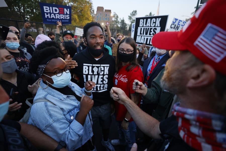 FILE - In this Oct. 7, 2020, file photo, supporters for former Vice President Joe Biden and Black Lives Matter, clash with President Donald Trump supporters prior to the vice presidential debate in Salt Lake City. Several years since its founding, BLM has evolved well beyond the initial aspirations of its early supporters. Now, its influence faces a test, as voters in the Tuesday, Nov. 3 general election choose or reject candidates who endorsed or denounced the BLM movement amid a national reckoning on race.