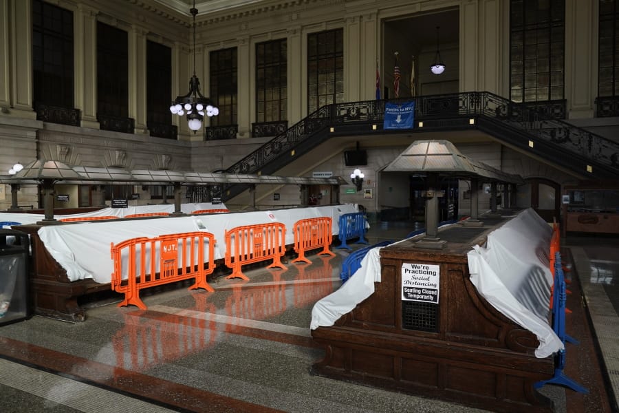 Tarps and fences block the seating area in the Hoboken Terminal waiting room in Hoboken, N.J., Tuesday, Oct. 27, 2020. Once a gleaming symbol of early 20th-century ambition and prosperity, the grand rail terminal now sits as a somber reminder of the daunting challenges facing mass transit in the New York region.