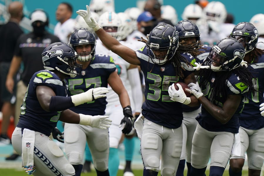 Seattle Seahawks cornerback Ryan Neal (35) is celebrated by his teammates after intercepting a pass, during the first half of an NFL football game against the Miami Dolphins, Sunday, Oct. 4, 2020 in Miami Gardens, Fla.