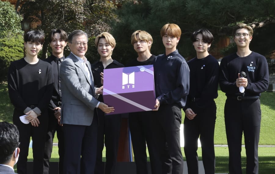 South Korean President Moon Jae-in, third from left, receives a gift from members of South Korean K-Pop group BTS during a ceremony marking the National Youth Day at the presidential Blue House in Seoul, South Korea, Saturday, Sept. 19, 2020.