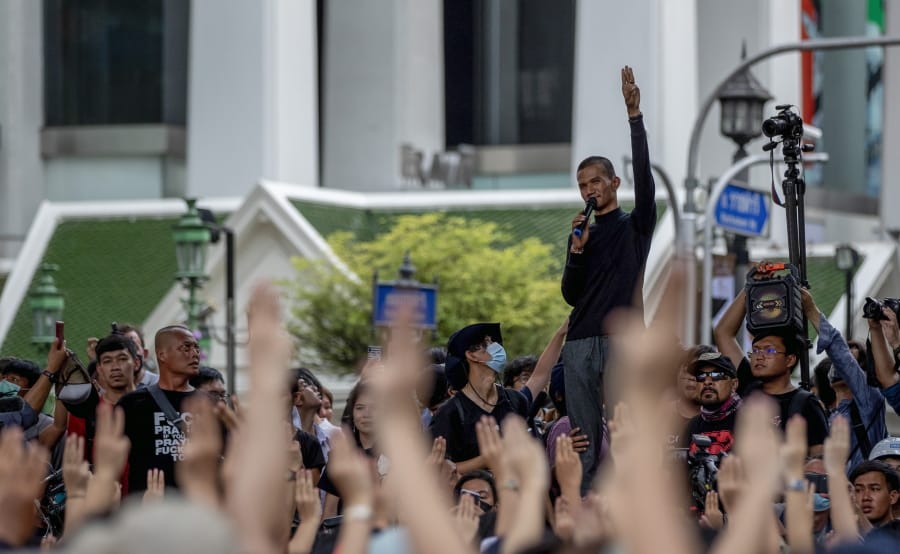 A man raises three-finger salutes, a symbol of resistance, as he speaks to pro-democracy protesters during a protest at the central business district in Bangkok, Thailand, Thursday, Oct. 15, 2020. Thailand&#039;s government declared a strict new state of emergency for the capital on Thursday, a day after a student-led protest against the country&#039;s traditional establishment saw an extraordinary moment in which demonstrators heckled a royal motorcade.