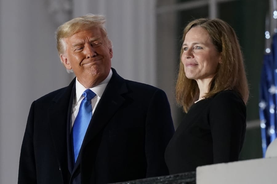 President Donald Trump and Amy Coney Barrett stand on the Blue Room Balcony after Supreme Court Justice Clarence Thomas administered the Constitutional Oath to her on the South Lawn of the White House White House in Washington, Monday, Oct. 26, 2020. Barrett was confirmed to be a Supreme Court justice by the Senate earlier in the evening.