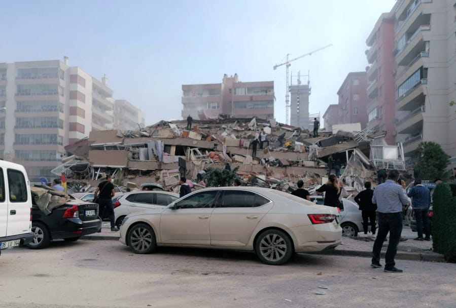 People work on a collapsed building, in Izmir, Turkey, Friday, Oct. 30, 2020, after a strong earthquake in the Aegean Sea has shaken Turkey and Greece.