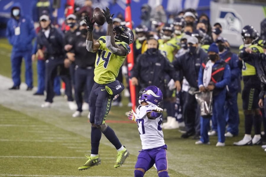 Seattle Seahawks&#039; DK Metcalf (14) pulls in a long pass reception on the Seahawks&#039; last series of an NFL football game as Minnesota Vikings&#039; Cameron Dantzler defends late in the second half, Sunday, Oct. 11, 2020, in Seattle. The Seahawks won 27-26. (AP Photo/Ted S.