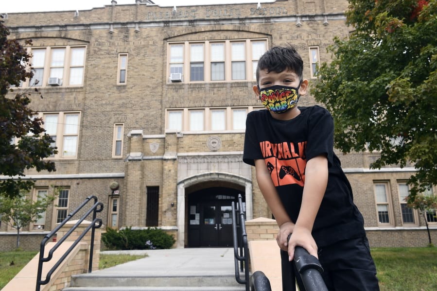 Second grade student Mason Negron, 6, whose mother Kristina Negron was laid off from her job as an aide for a special education class at Schenectady High School, due to budget cuts, poses for a photograph at his Pleasant Valley Elementary school Tuesday, Sept. 29, 2020, in Schenectady, N.Y.