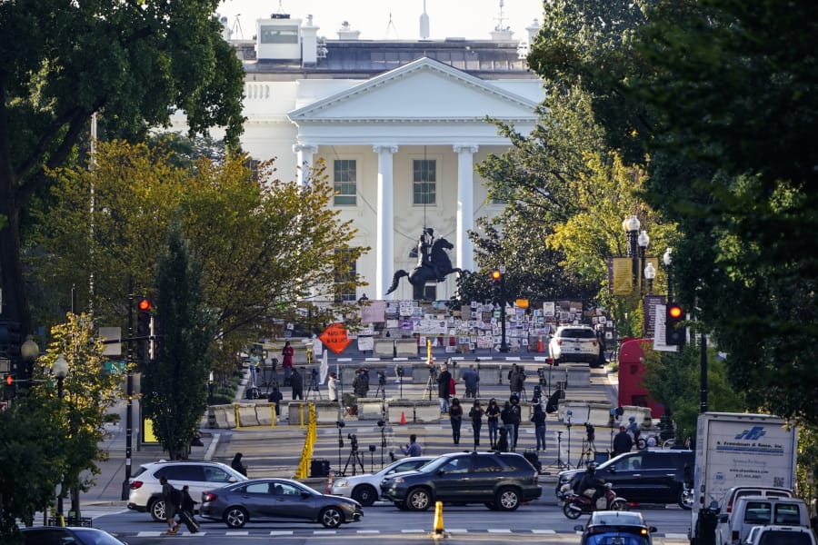 The White House is seen in Washington, early Tuesday, Oct. 6, 2020, the morning after President Donald Trump returned from the hospital where he was treated for COVID-19. Traffic moves along K Street NW as TV crews set up in Black Lives Matter Plaza. (AP Photo/J.