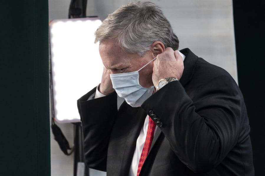 White House chief of staff Mark Meadows replaces his face covering after a television interview at the White House, Wednesday, Oct. 7, 2020, in Washington.