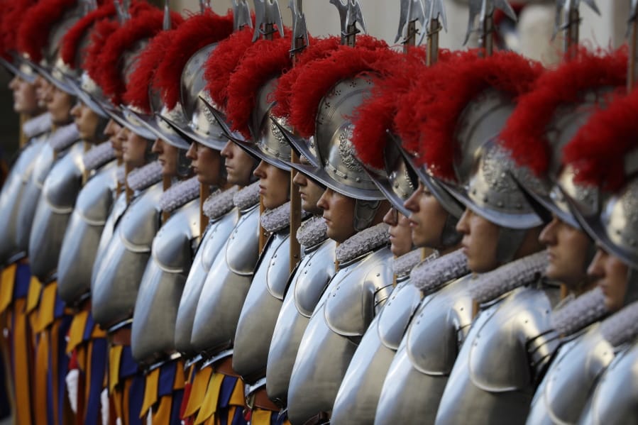 FILE - In this Oct. 4, 2020 file photo, Vatican Swiss Guards stand attention at the St. Damaso courtyard on the occasion of their swearing-in ceremony, at the Vatican, Sunday, Oct. 4, 2020. On Monday, Oct. 12, 2020, the Vatican said in a statement  that four Swiss Guards have tested positive for the coronavirus, as the surge in infections in surrounding Italy enters the Vatican walls.