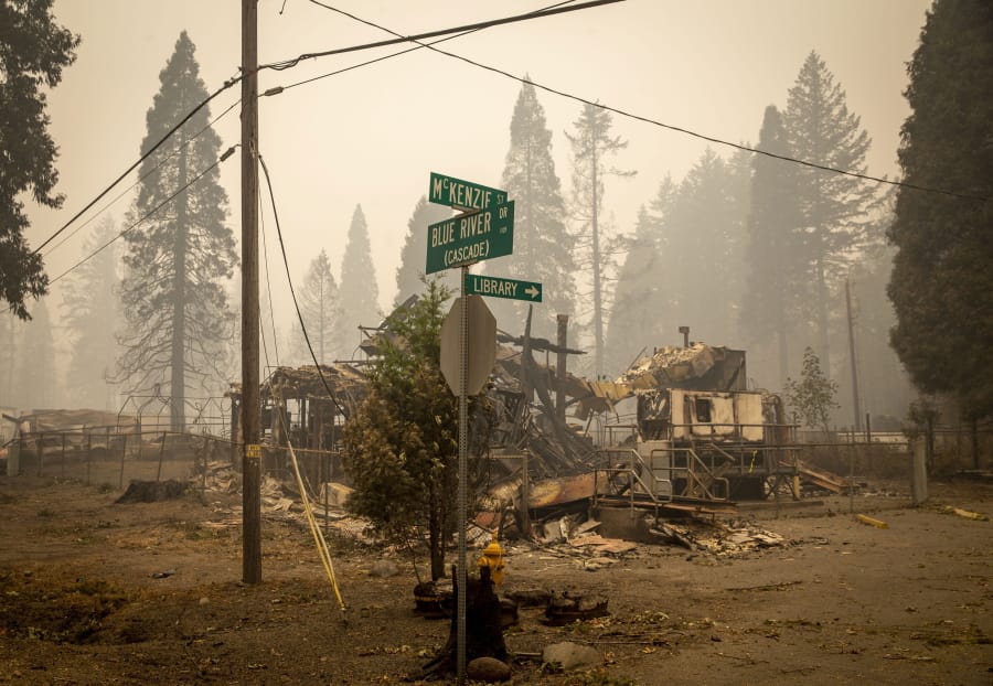 FILE - In this Sept. 15, 2020, file photo, scorched property stands at an intersection in Blue River, Ore., days after a blaze known as the Holiday Farm Fire swept through the area&#039;s business district. Oregonians are grieving the loss of some of their most treasured natural places after wildfires wiped out campgrounds, hot springs and wooded retreats that have been a touchstone for generations in a state known for its unspoiled beauty.