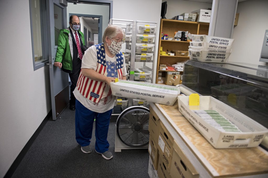 Greg Kimsey, Clark County Auditor, left, looks on as ballot inspector Wendy Wimer lends a hand at the Clark County Elections Office on Tuesday afternoon, Nov. 3, 2020.