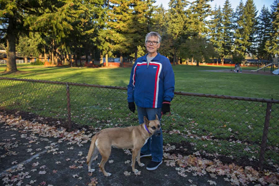 Karen Bean of Vancouver and her dog, DeeDee, pause for a portrait at Hearthwood Park. Bean has volunteered to pull weeds and clean the park.