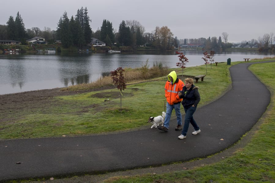 Matt and Fran Gray of La Center keep in step with their dog, Riley, during a lunchtime stroll Nov. 20 at Horseshoe Lake Park in Woodland. The lake is located in both Clark and Cowlitz counties. It used to be part of the Lewis River but was cut off from the waterway when Highway 99, now Interstate 5, was constructed.