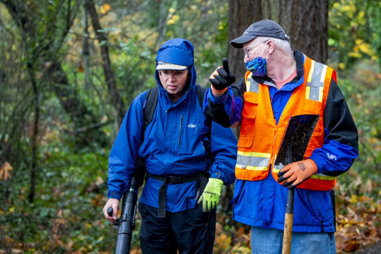 Dale Meier, left, listens to instructions from event organizer Jeff Wills on Saturday afternoon on the Interstate 205 bike path off of Highway 14. Several people assisted in clearing the bike path of leaves, garbage and roots.
