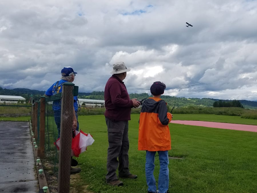Robert Overgaard, Bruce Wasill and Owen Childers, from left to right, fly a model airplane in June at the Port of Camas-Washougal.
