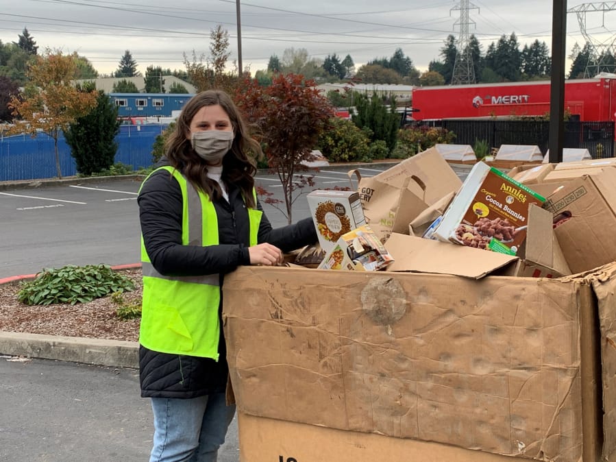 Ali Laskowski, events coordinator at the Clark County Food Bank, puts food into a tote box. The food bank will be one of eight drop-off sites for this year&#039;s Walk &amp; Knock food drive on Dec. 5.