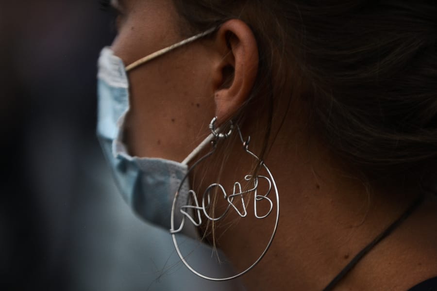DENVER, CO - JUNE 01: A woman wears an &quot;ACAB&quot; earring as people crowd in front of the Colorado State Capitol to protest on June 1, 2020 in Denver, Colorado. Protests continue in cities across the country after George Floyd, a black man, died in police custody in Minneapolis on May 25th.