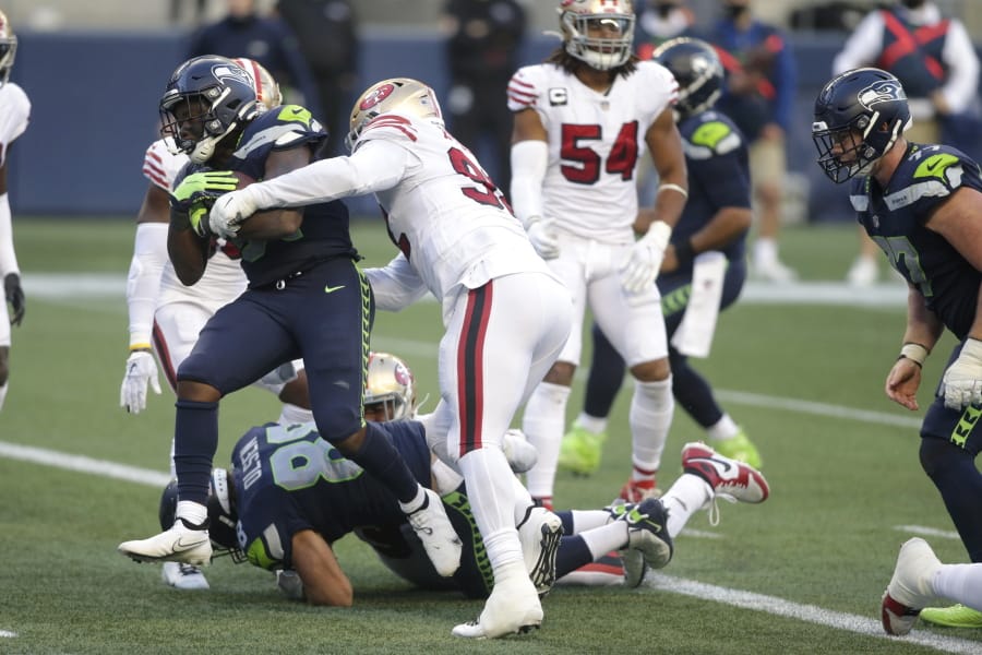 Seattle Seahawks running back DeeJay Dallas, left, scores a touchdown against the San Francisco 49ers during the second half of an NFL football game, Sunday, Nov. 1, 2020, in Seattle. The Seahawks won 37-27.