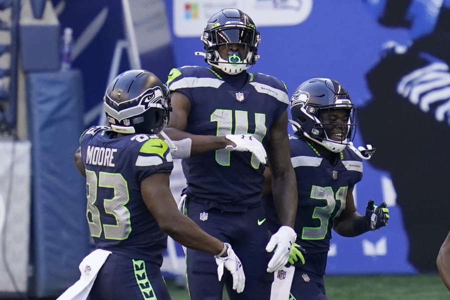 Seattle Seahawks wide receiver DK Metcalf (14) celebrates with teammates David Moore, left, and DeeJay Dallas, right, after Metcalf scored a touchdown against the San Francisco 49ers during the first half of an NFL football game, Sunday, Nov. 1, 2020, in Seattle.
