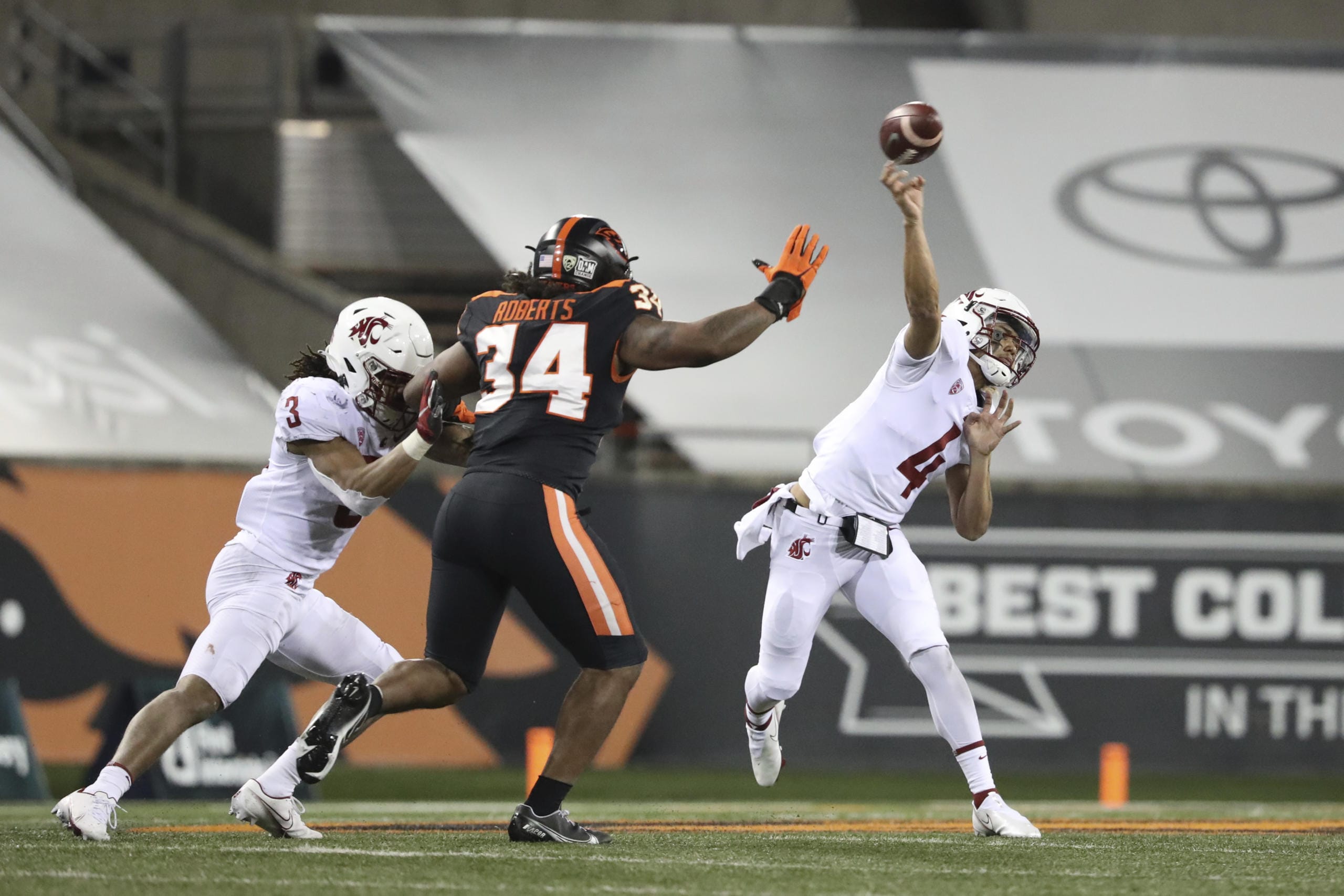 Washington State quarterback Jayden de Laura (4) throws past Oregon State inside linebacker Avery Roberts (34) and Washington State's Deon McIntosh (3) during the first half of an NCAA college football game in Corvallis, Ore., Saturday, Nov, 7, 2020.