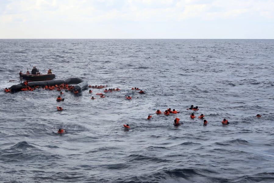 Refugees and migrants are rescued by members of the Spanish NGO Proactiva Open Arms, after leaving Libya trying to reach European soil aboard an overcrowded rubber boat in the Mediterranean sea, Wednesday, Nov. 11, 2020. The Open Arms rescue ship had been searching for the boat in distress for hours before finally finding it Wednesday morning in international waters north of Libya. The NGO had just finished distributing life vests and masks to the passengers to begin transferring them to safety when the flimsy boat split in half throwing them into cold waters.