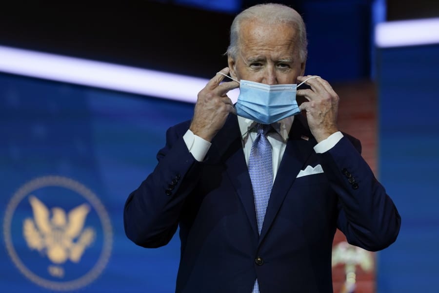 President-elect Joe Biden removes his face mask as he arrives Tuesday to introduce his nominees and appointees to key national security and foreign policy posts at The Queen theater in Wilmington, Del.