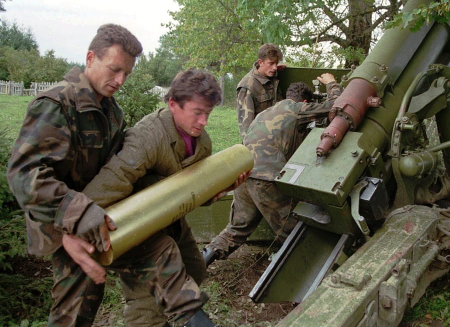 FILE - In this Oct. 4, 1995. file photo, Bosnian government soldiers load a 130mm howitzer with shells at their artillery position near the Serb-held town of Sanski Most, some 60 miles northwest of Sarajevo, Bosnia. While it brought an end to the fighting, the Dayton peace agreement baked in the ethnic divisions, establishing a complicated and fragmented state structure with two semi-autonomous entities, Serb-run Republika Srpska and a Federation shared by Bosniak and Croats, linked by weak joint institutions.