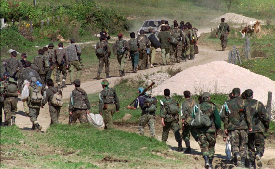 FILE - In this Sept. 28, 1995. file photo, a line of Bosnian government troops makes its way to the front-line near Mrkonjic Grad 120kms (80mls) north west of Sarajevo, Bosnia. While it brought an end to the fighting, the Dayton peace agreement baked in the ethnic divisions, establishing a complicated and fragmented state structure with two semi-autonomous entities, Serb-run Republika Srpska and a Federation shared by Bosniak and Croats, linked by weak joint institutions.