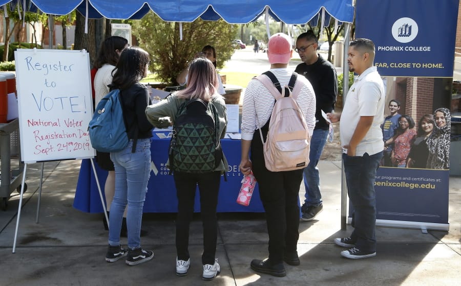 FILE - In this Sept. 24, 2019 file photo students at Phoenix College gather to fill out voter registration forms on National Voter Registration Day on campus, in Phoenix. Immigrant-rights and grassroots organizations that have been mobilizing Latinos in Arizona for nearly two decades helped propel Joe Biden to victory in a traditionally conservative state.  (AP Photo/Ross D.