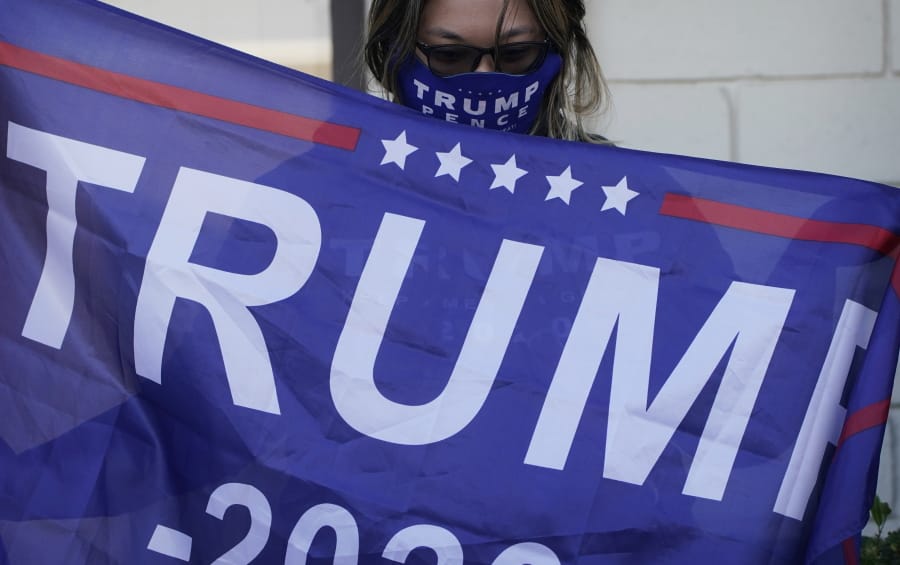 A supporter of President Donald Trump holds a flag during a news conference Tuesday, Nov. 17, 2020, in Las Vegas.
