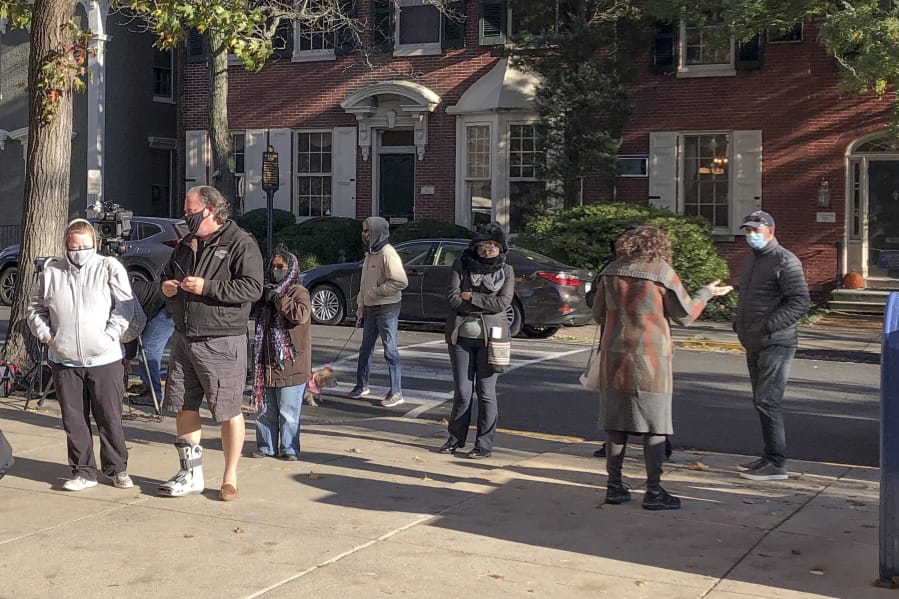 Voters wait in line outside the Bucks county government building in Doylestown, Pa., a suburb of Philadelphia, on Monday, Nov. 2, 2020. Some said they received word that their mail-in ballots had problems and needed to be fixed in order to count.