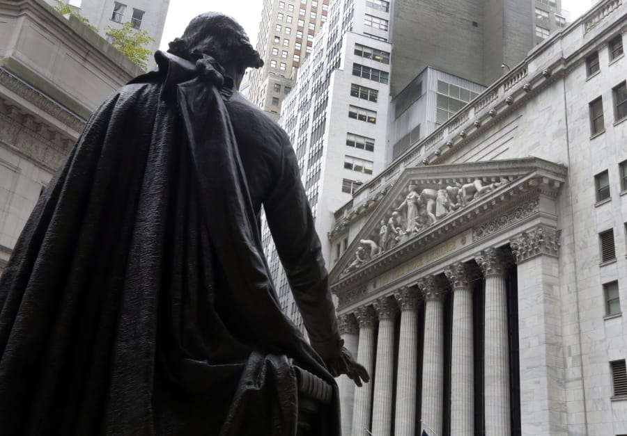 FILE - In this Oct. 2, 2014, file photo, a statue of President George Washington on the steps of Federal Hall faces the facade of the New York Stock Exchange.  U.S. stock futures and markets around the world are mostly holding steady or ticking higher early Wednesday, Nov. 4, 2020, but that&#039;s only after they spun through another election night dominated by surprises and sharp swings.