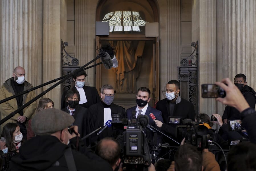 Alek Skarlatos, center right, Anthony Sadler, right, Mark Moogalian, left, and their lawyer Thibault de Montbrial, center left, deliver a speech during the Thalys attack trial at the Paris courthouse, Friday, Nov. 20, 2020. Passengers who wrestled and disarmed an Islamic State gunman aboard a high-speed Amsterdam to Paris train are recounting how their split-second decisions helped prevent what could have become a mass slaughter.