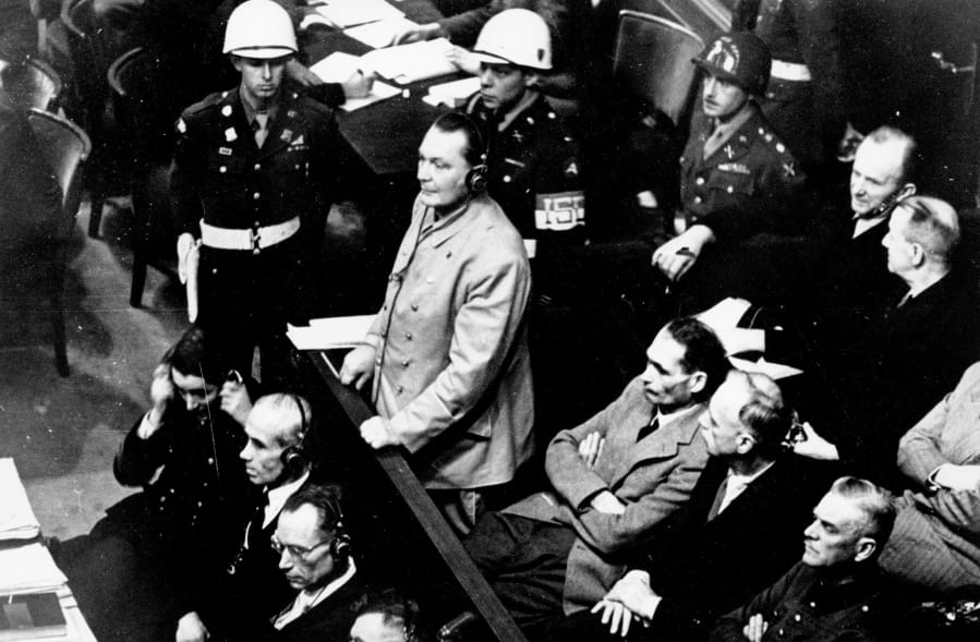 Reichsmarshal Hermann Goering stands in the dock at the Nuremberg War Crimes Trials in Germany on Nov. 21, 1945. Wearing headphones for the translating system, he is entering a plea of not guilty to the International Military Tribunal Indictment.
