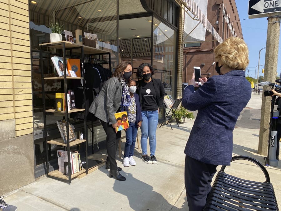 Michigan Sen. Debbie Stabenow, right, takes a picture of Vice President-elect Kamala Harris posing for a photo on Sept. 22, 2020 with Egypt Otis and her nine-year-old daughter Eva Allen in front of their downtown Flint, Mich., bookstore, the Comma Bookstore &amp; Social Hub. For countless women and girls, Harris&#039; achievement of reaching the second highest office in the country represents hope, validation and the shattering of a proverbial glass ceiling that has kept mostly white men perched at the top tiers of American government. &quot;My daughter is going to be a part of history because she had the opportunity to have a conversation with our first Black woman vice president,&quot; said Otis.