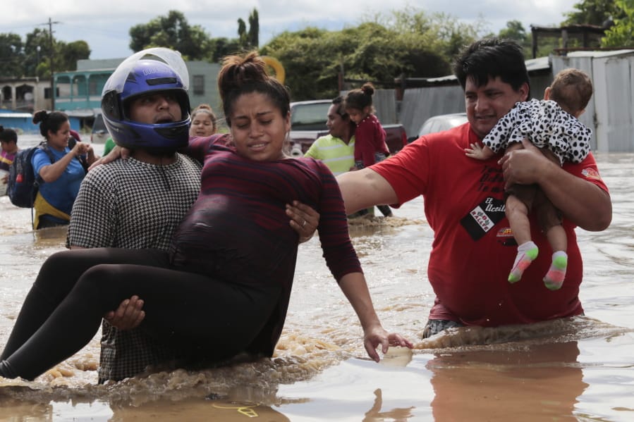 A pregnant woman is carried out of an area flooded by water brought by Hurricane Eta in Planeta, Honduras, Thursday, Nov. 5, 2020. The storm that hit Nicaragua as a Category 4 hurricane on Tuesday had become more of a vast tropical rainstorm, but it was advancing so slowly and dumping so much rain that much of Central America remained on high alert.