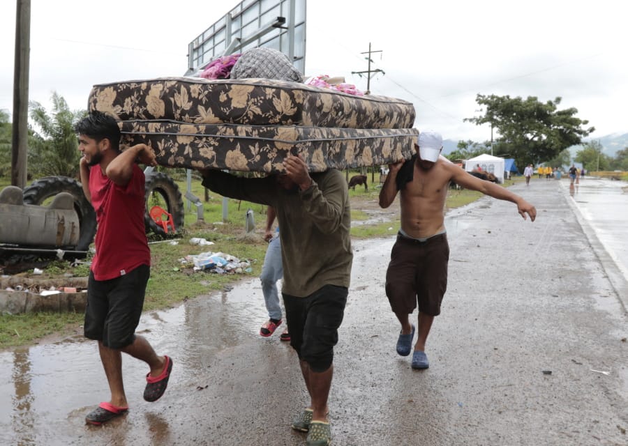 Neighbors help each other as they evacuate the area before Hurricane Iota makes landfall in San Manuel Cortes, Honduras, Monday, November 16, 2020. Hurricane Iota rapidly strengthened into a Category 5 storm that is likely to bring catastrophic damage to the same part of Central America already battered by a powerful Hurricane Eta less than two weeks ago.